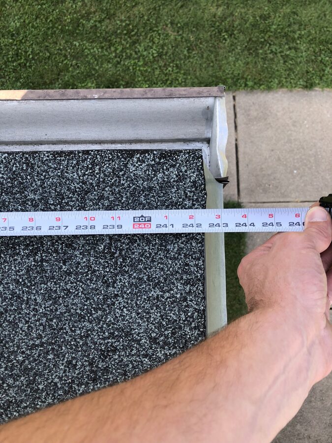 Measuring drip edge overhang during roof inspection in Omaha