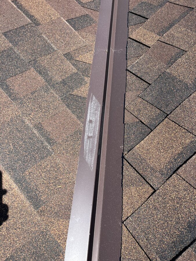 Hail dent on metal roof flashing found during storm damage inspection